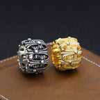 Two jeweled chrome rings: silver-tone and gold-tone with ornate stone setting