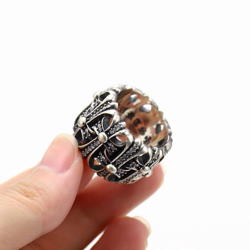 Silver-tone ornate chrome ring with diamond-like stones close-up on finger