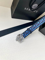 Versace belt strap detail with silver Medusa buckle and blue geometric pattern strip.