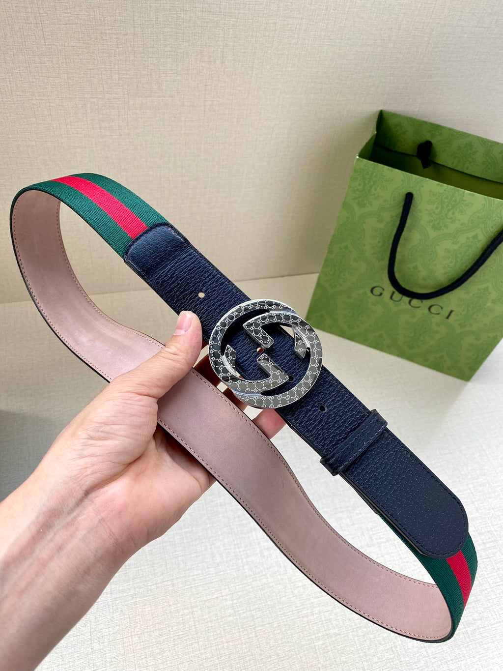 Gucci belt with pink lining; navy strap, silver round buckle, and green-red web stripe