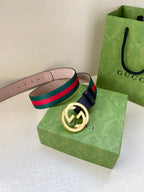 Gucci belt with navy strap, green-red striped band, and gold-toned GG buckle