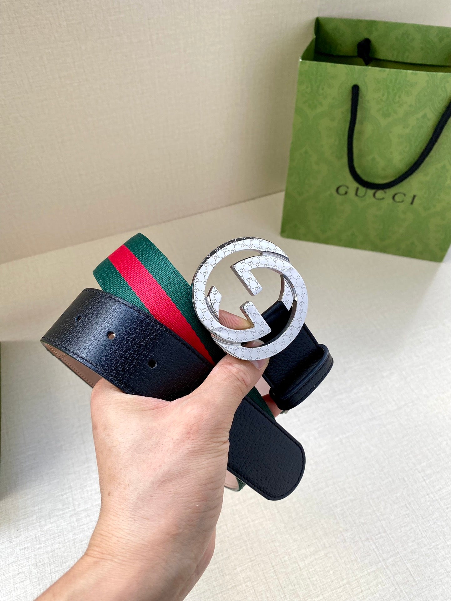 Gucci belt with navy strap, large silver-toned G buckle, and green-red striped band