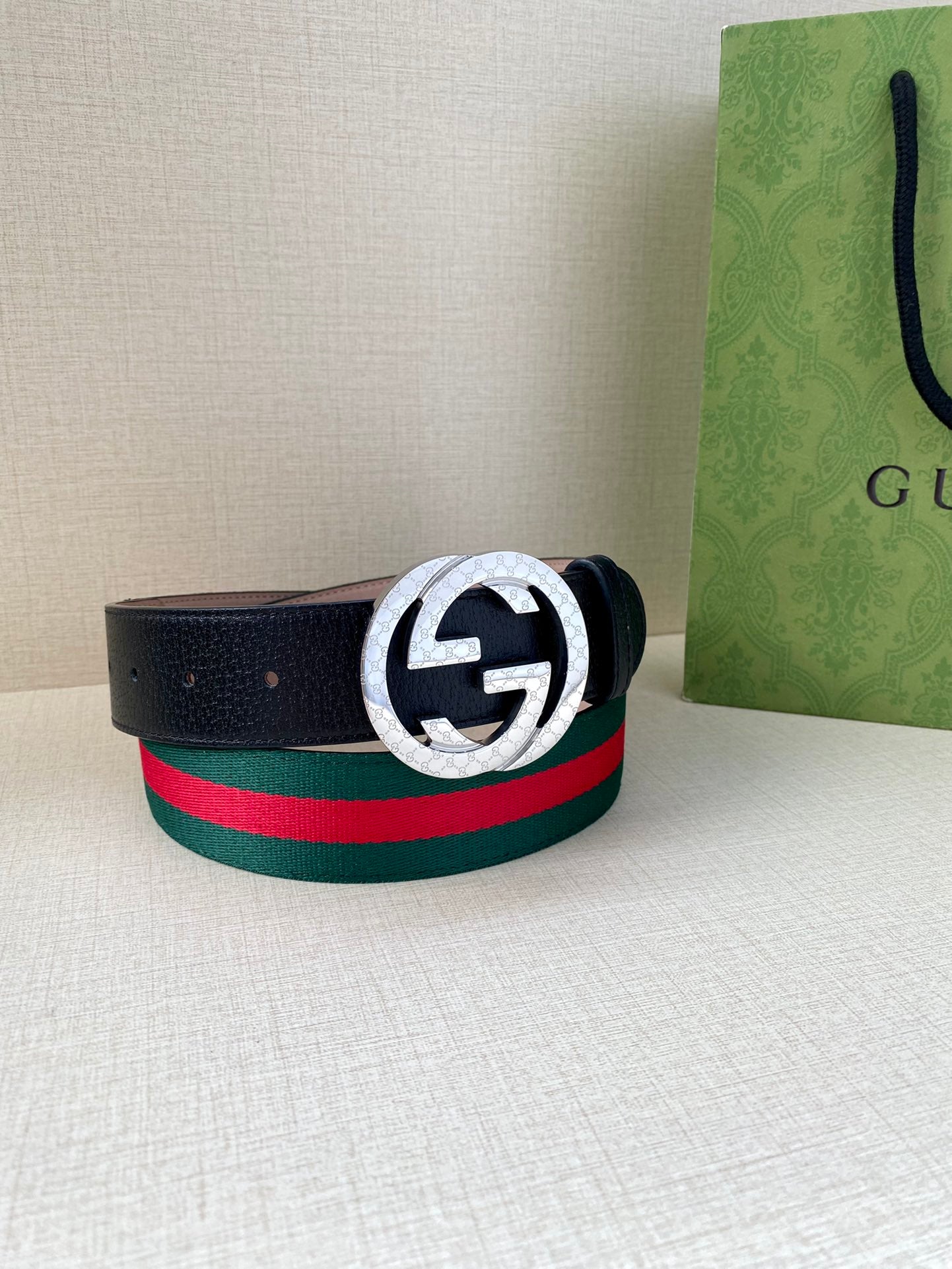 Gucci belt with navy leather and green-red striped web; silver-toned GG buckle