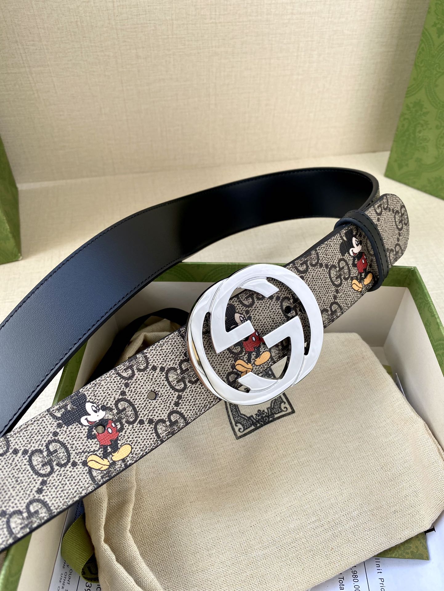 Gucci belt with navy GG monogram and Mickey print strap; silver interlocking G buckle
