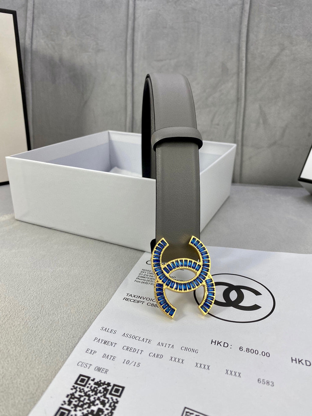 Chanel belt in light gray leather with blue-and-gold logo buckle, single end shown