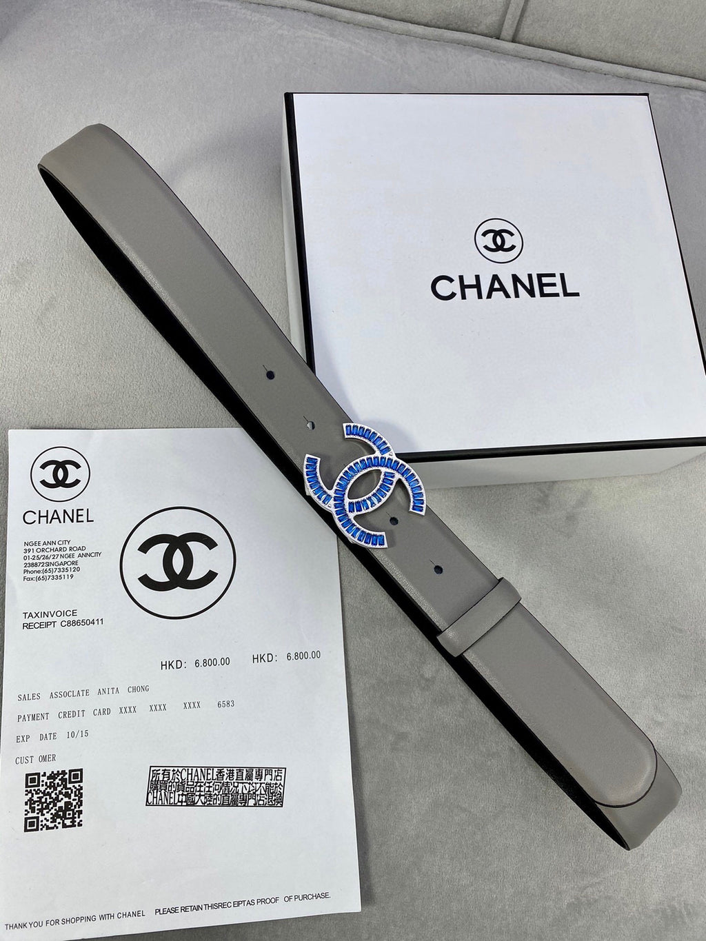 Chanel belt in light gray leather with blue-and-gold logo buckle, strap with holes
