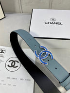 Light blue Chanel belt with blue and gold logo buckle on strap, angled close-up