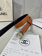 Tan leather belt with multicolor logo buckle on retail packaging