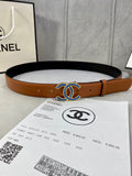 Tan leather belt with dark underside and multicolor jeweled logo buckle
