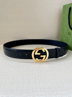 Dark navy leather belt with gold-toned circular GG buckle