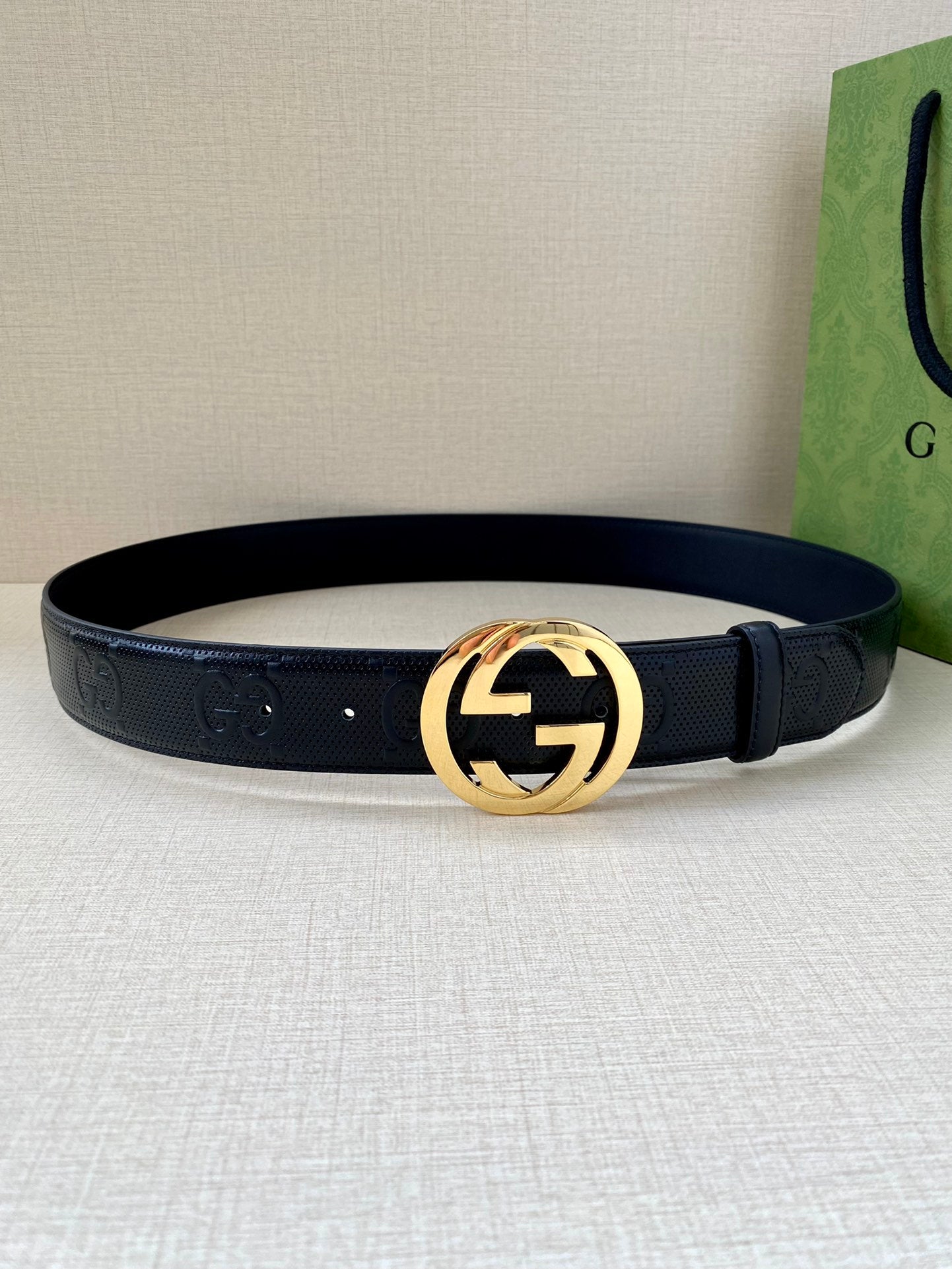 Dark navy leather belt with gold-toned circular GG buckle