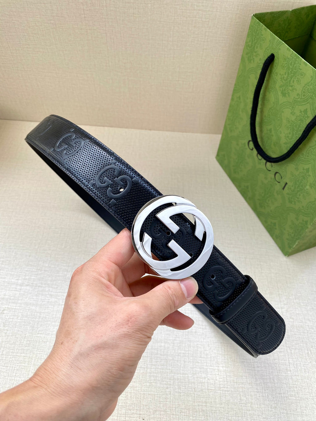 Navy leather belt with silver-toned circular GG logo buckle