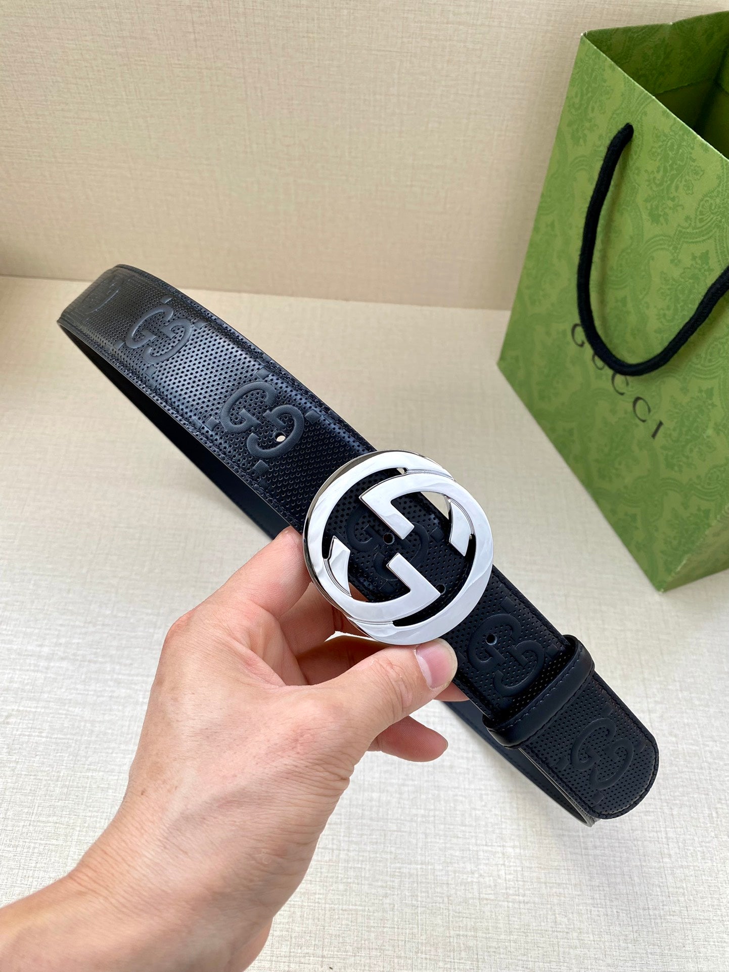 Navy leather belt with silver-toned circular GG logo buckle