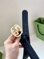 Navy leather belt with circular gold-tone logo buckle