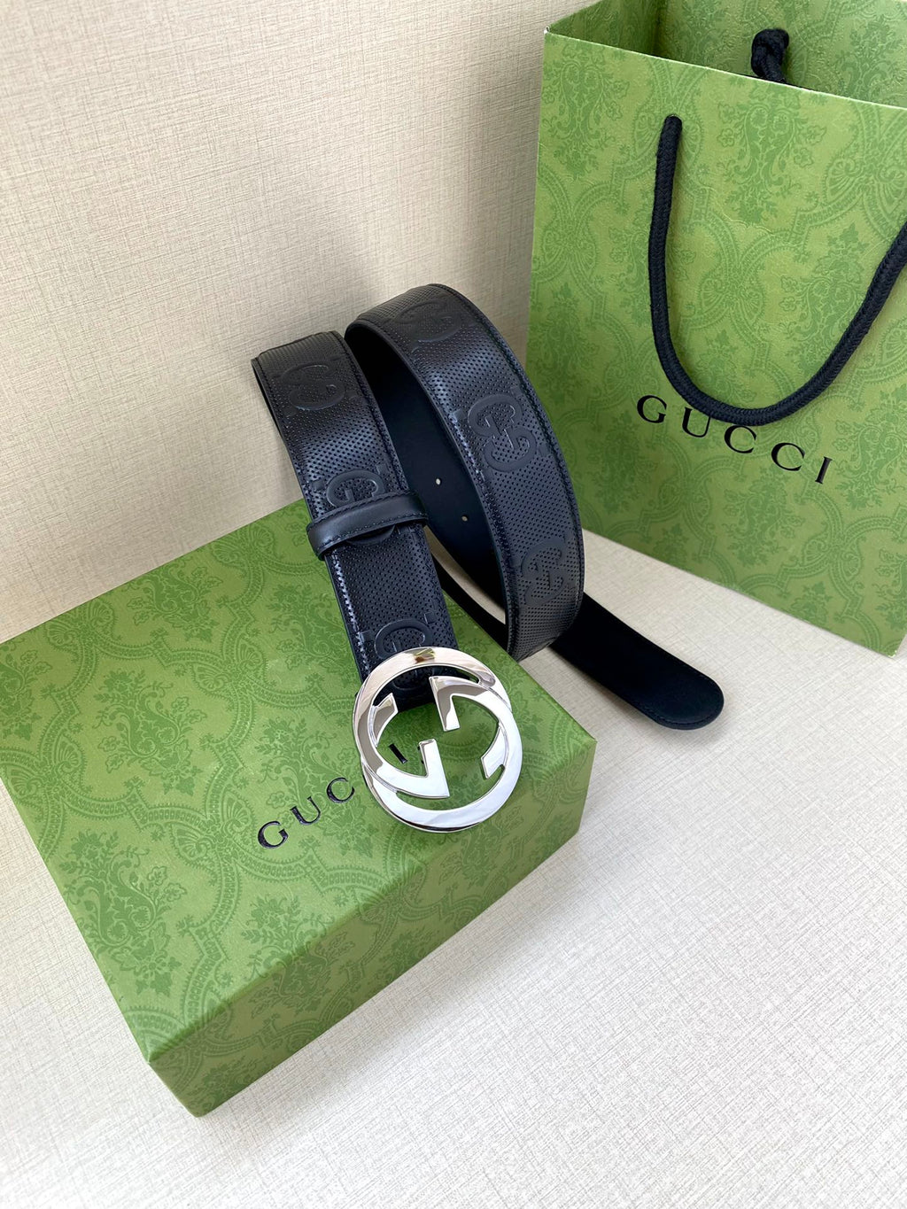 Navy belt with silver-toned circular logo buckle and belt end