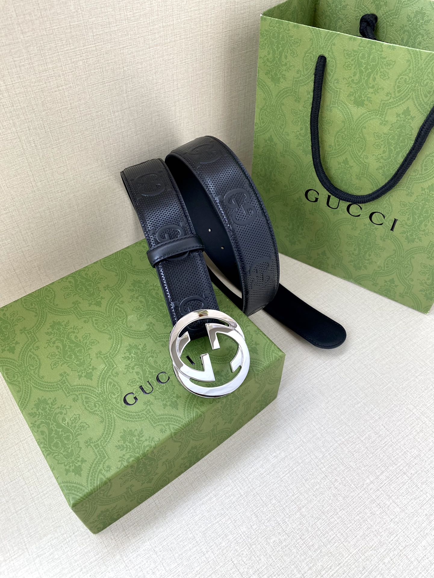 Navy belt with silver-toned circular logo buckle and belt end