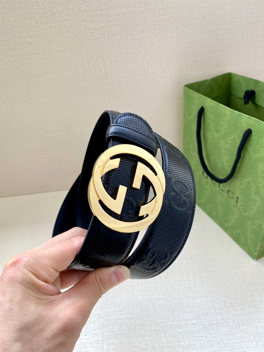 Navy textured belt with gold-toned circular logo buckle