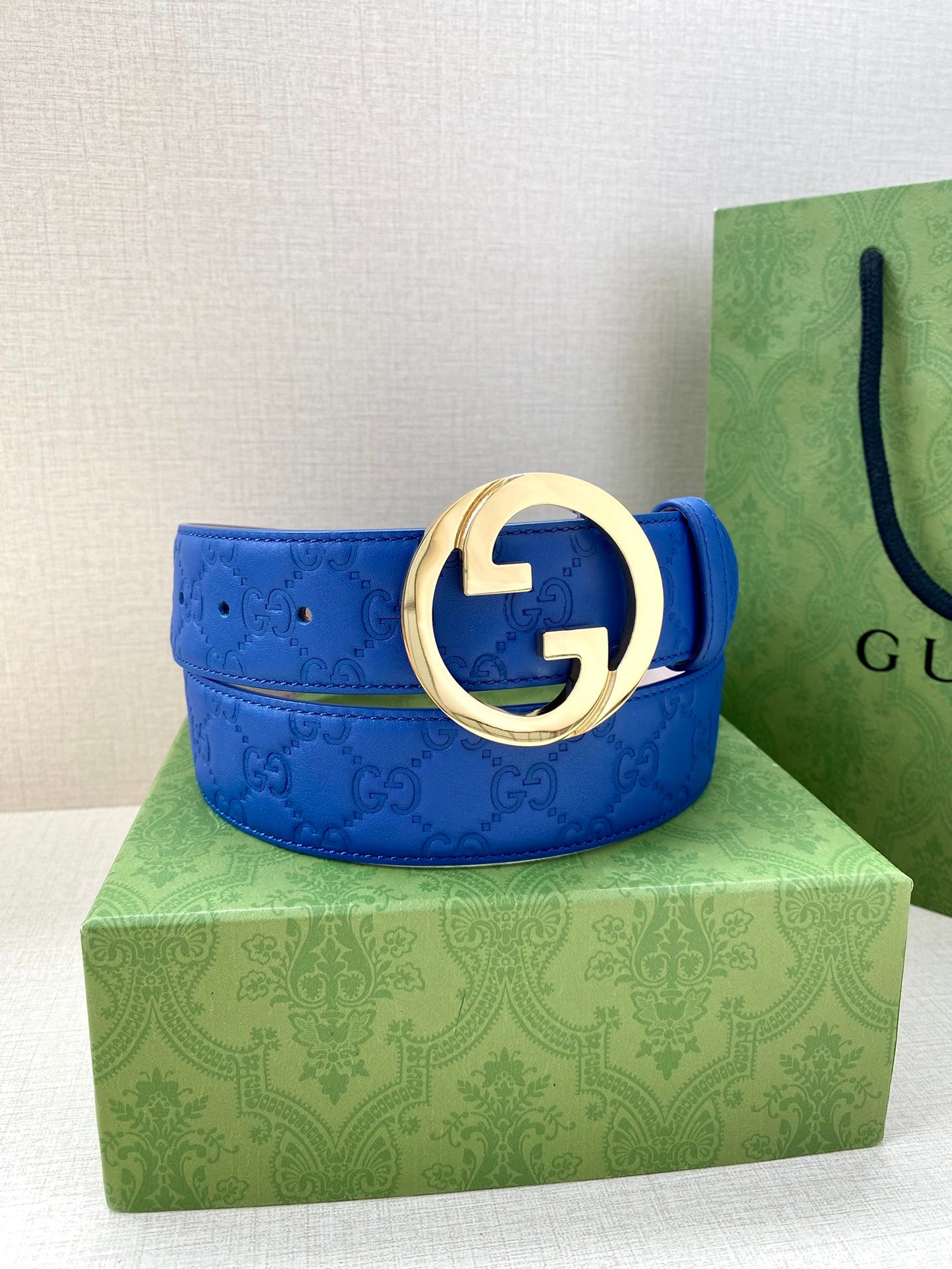 Gucci belt blue leather with gold-tone round interlocking GG buckle and smooth edges.