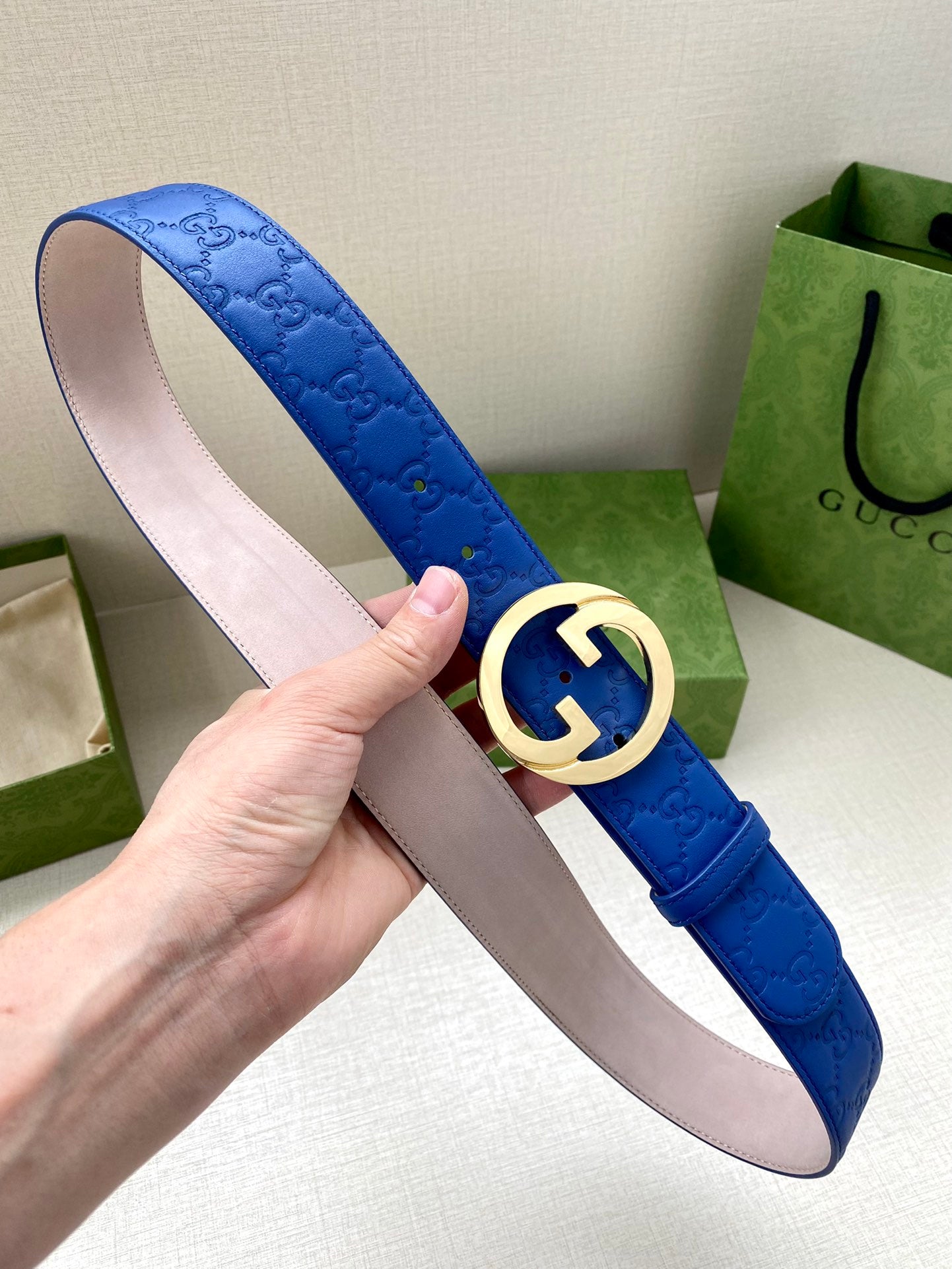 Gucci belt blue leather with gold-tone interlocking GG buckle and pale pink lining.