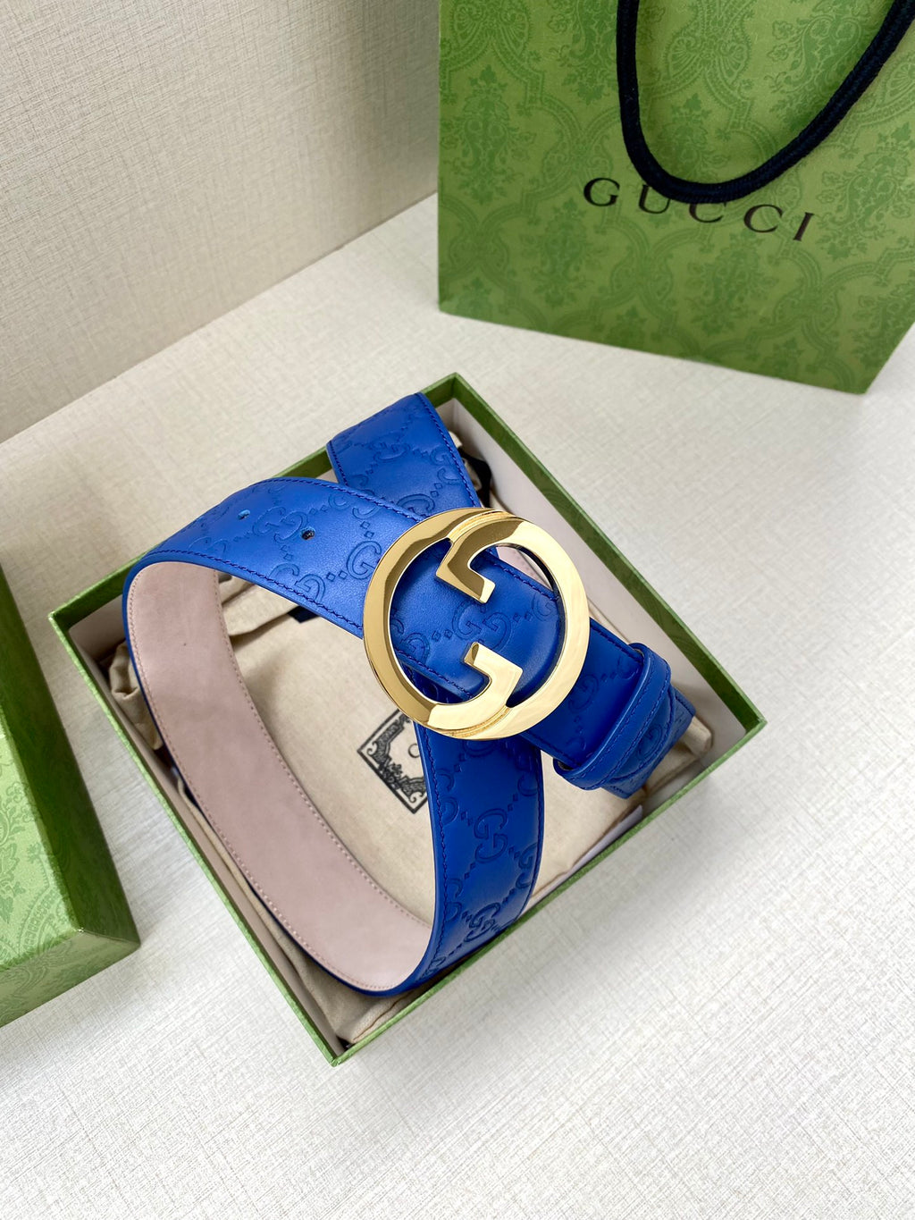 Gucci belt blue leather with gold-tone interlocking GG buckle and pale pink lining.