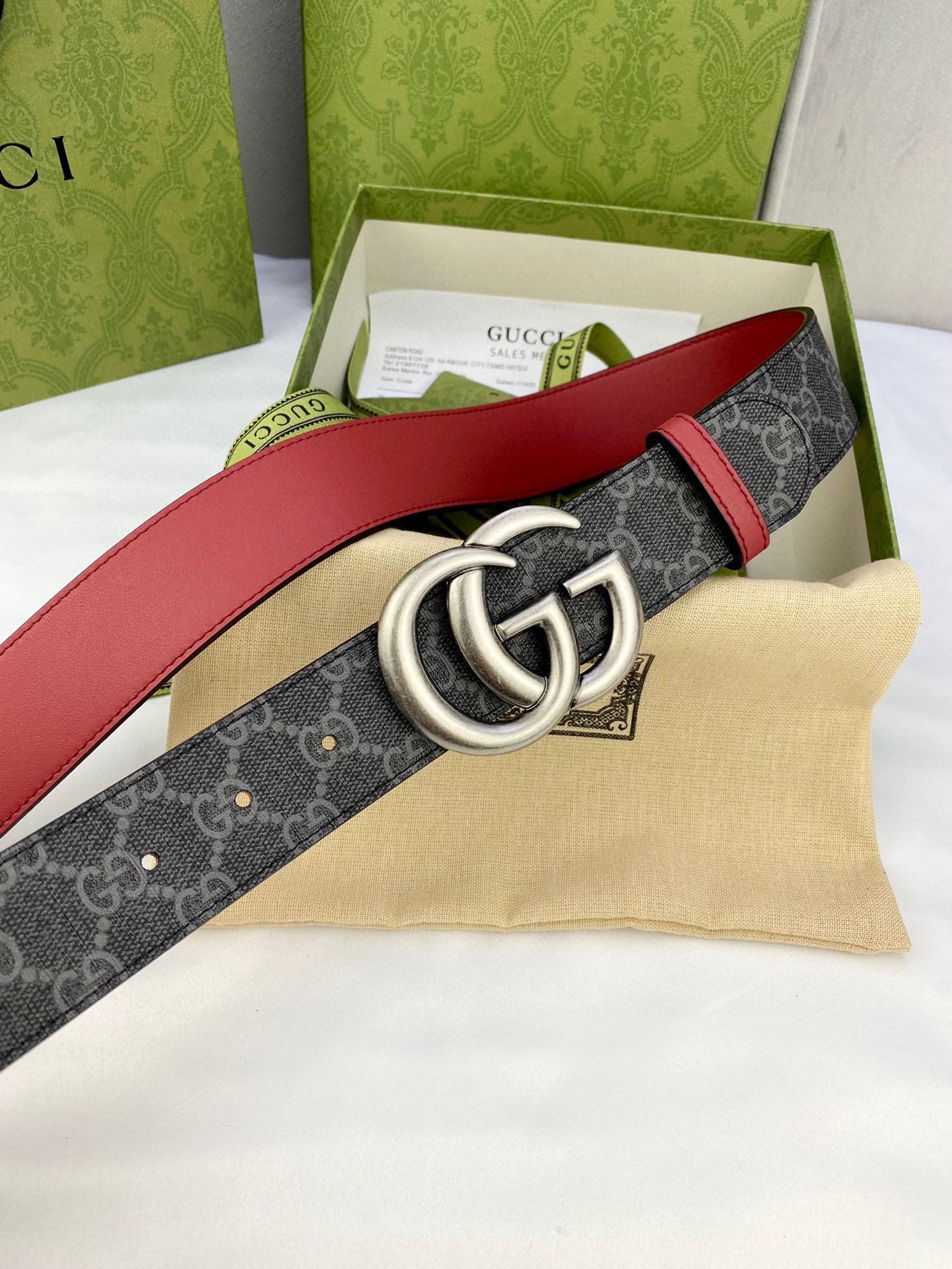 Gucci belt with dark GG-pattern strap and red sides, silver double-G buckle in box