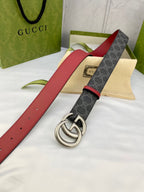 Gucci belt laid flat: dark GG-pattern strap, red leather sides, silver double-G buckle