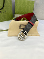 Gucci belt with dark GG monogram strap, red edge trim, and silver double-G buckle
