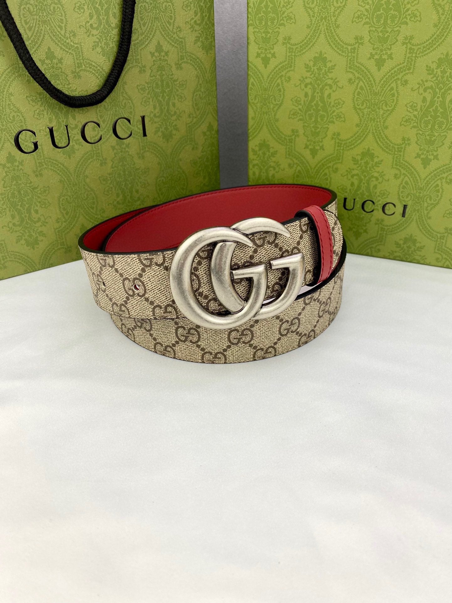 Gucci belt with GG canvas and red lining, silver double-G buckle, curved strap