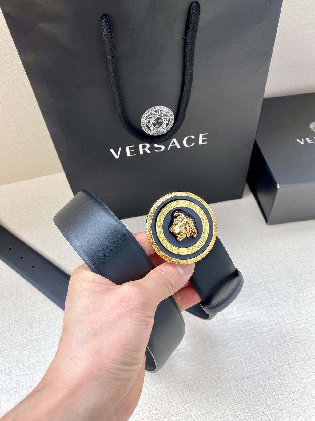 Versace belt detail: dark blue strap with round Medusa buckle