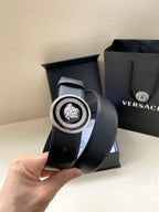 Versace dark blue belt, close-up of round Medusa buckle on curved strap