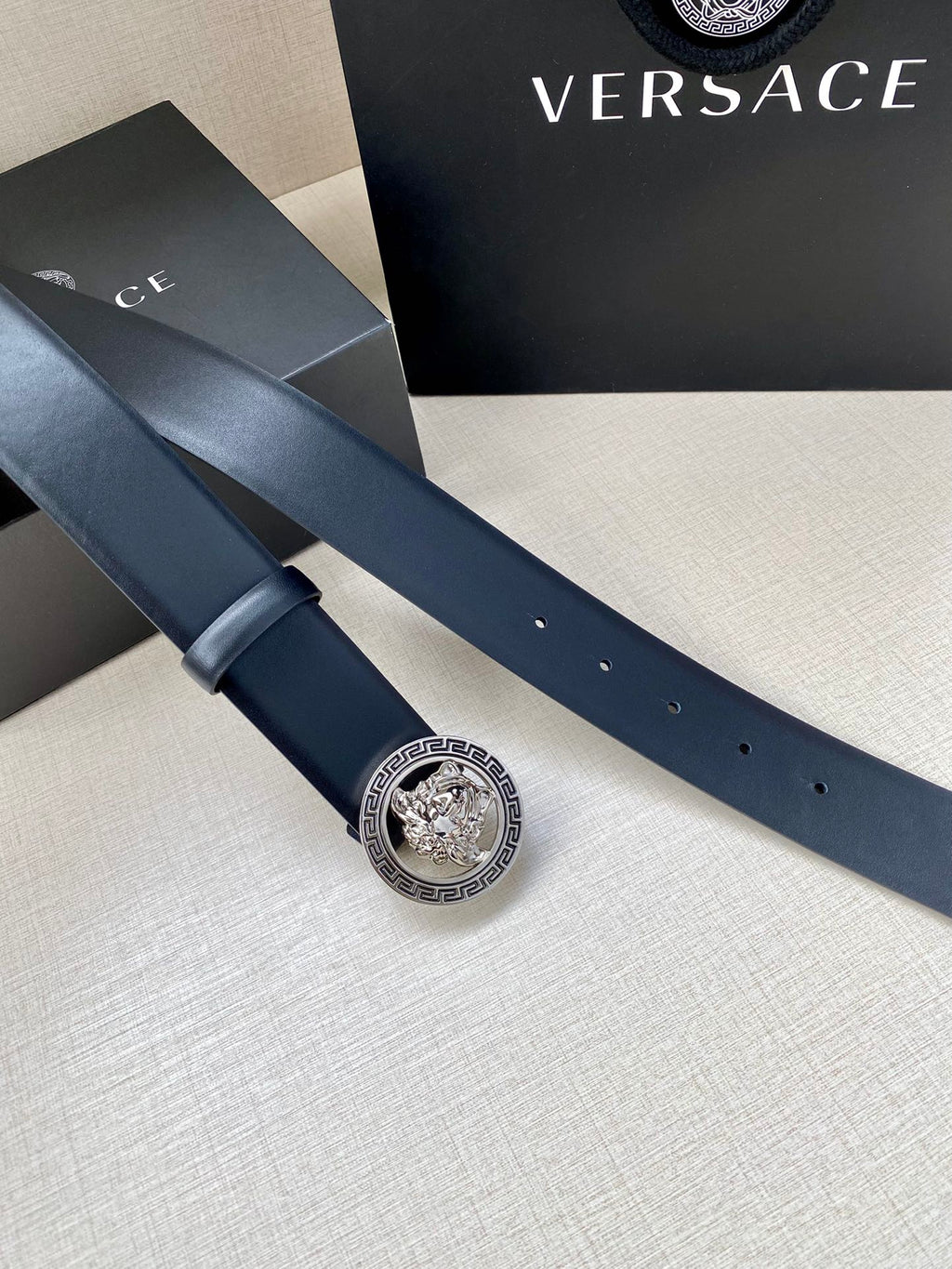 Dark blue leather belt with gold Medusa logo buckle and perforated holes