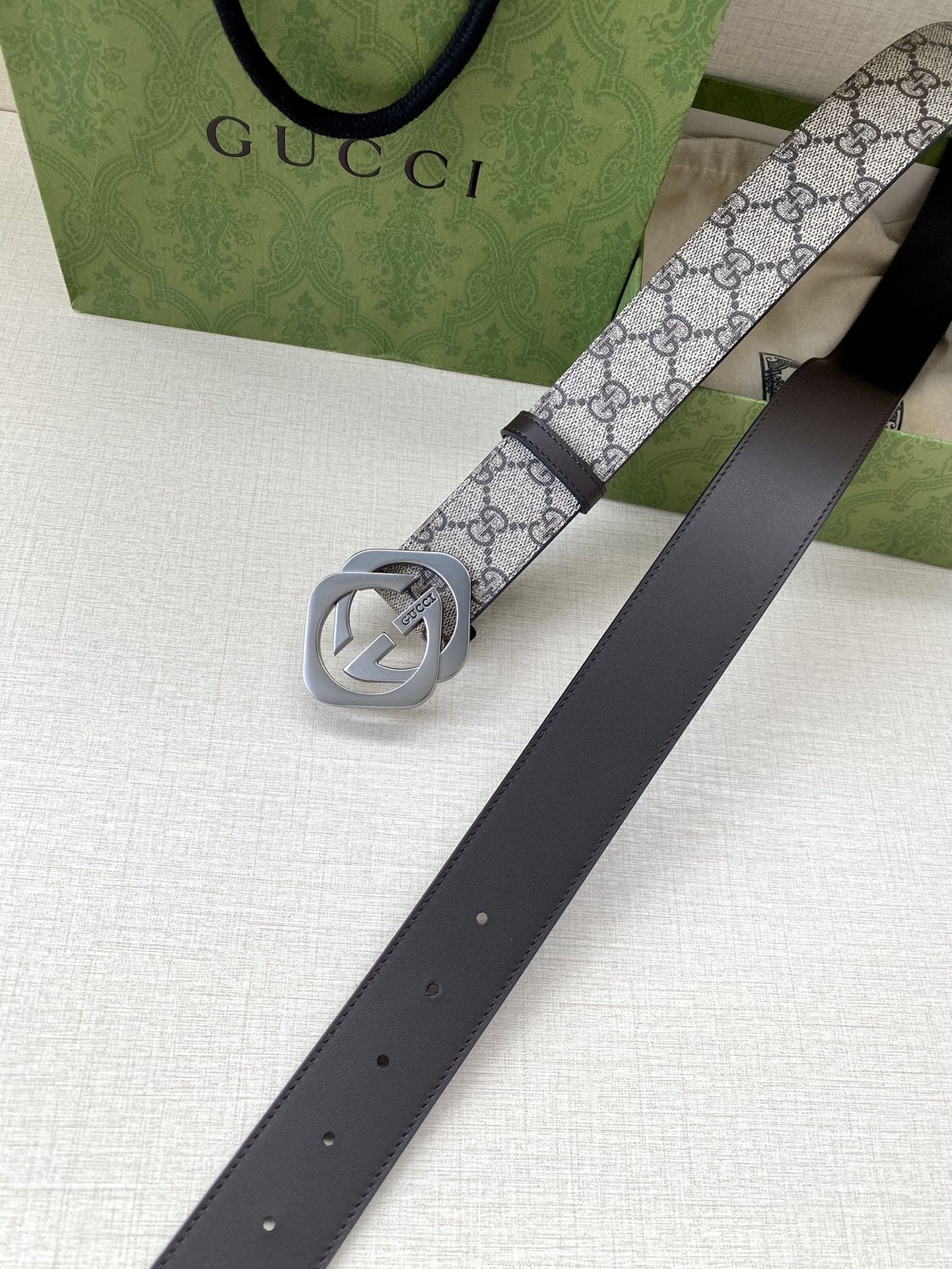 Gucci belt with GG canvas strap, silver interlocking G buckle, dark leather holes