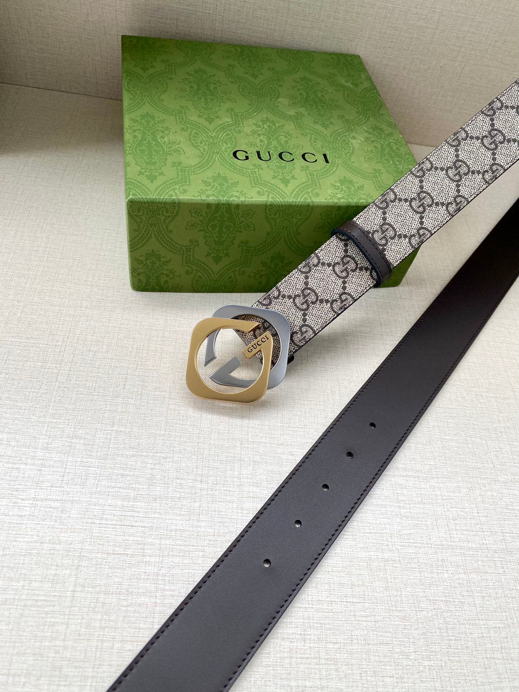 GG monogram belt with dark brown leather strap, gold buckle, and belt holes visible