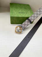 GG monogram belt with dark brown leather strap, gold buckle, and belt holes visible