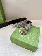GG monogram belt with dark brown leather strap and gold-toned buckle beside gift box