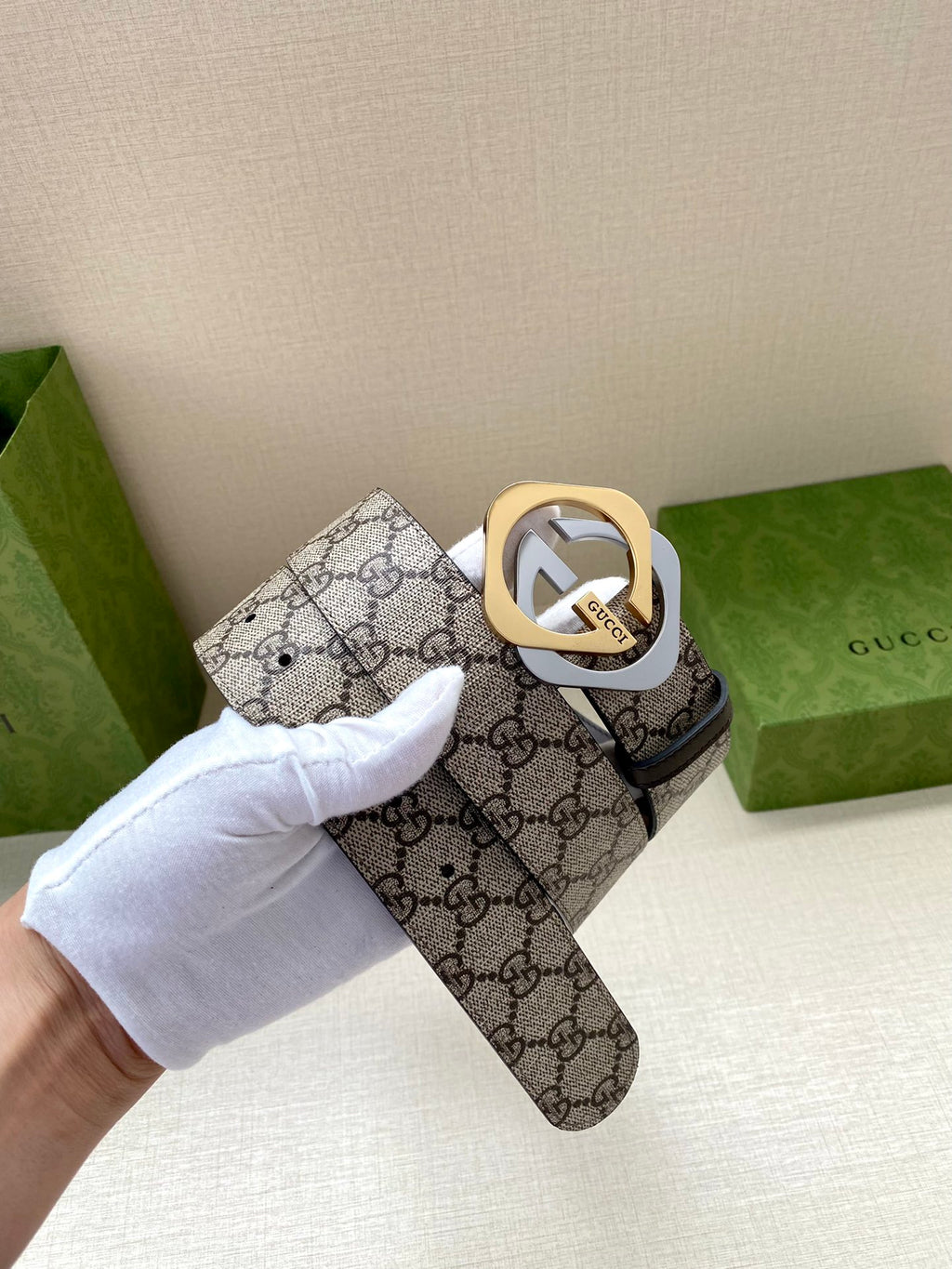 GG monogram belt with gold-toned logo buckle and dark brown leather strap, close detail