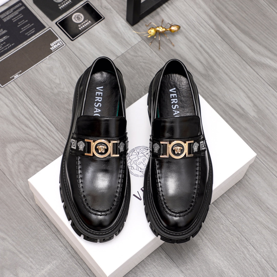 Black leather loafers with gold logo buckle, squared toe, chunky lug sole.