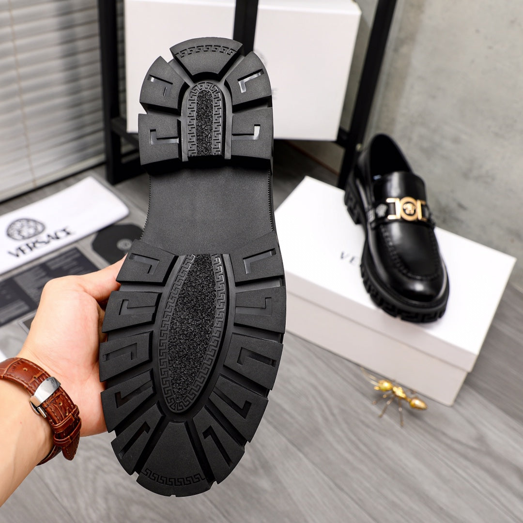Black leather loafer outsole view with textured tread and logo insole.