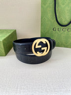 Gucci belt in dark navy with gold interlocking G buckle, flat on surface