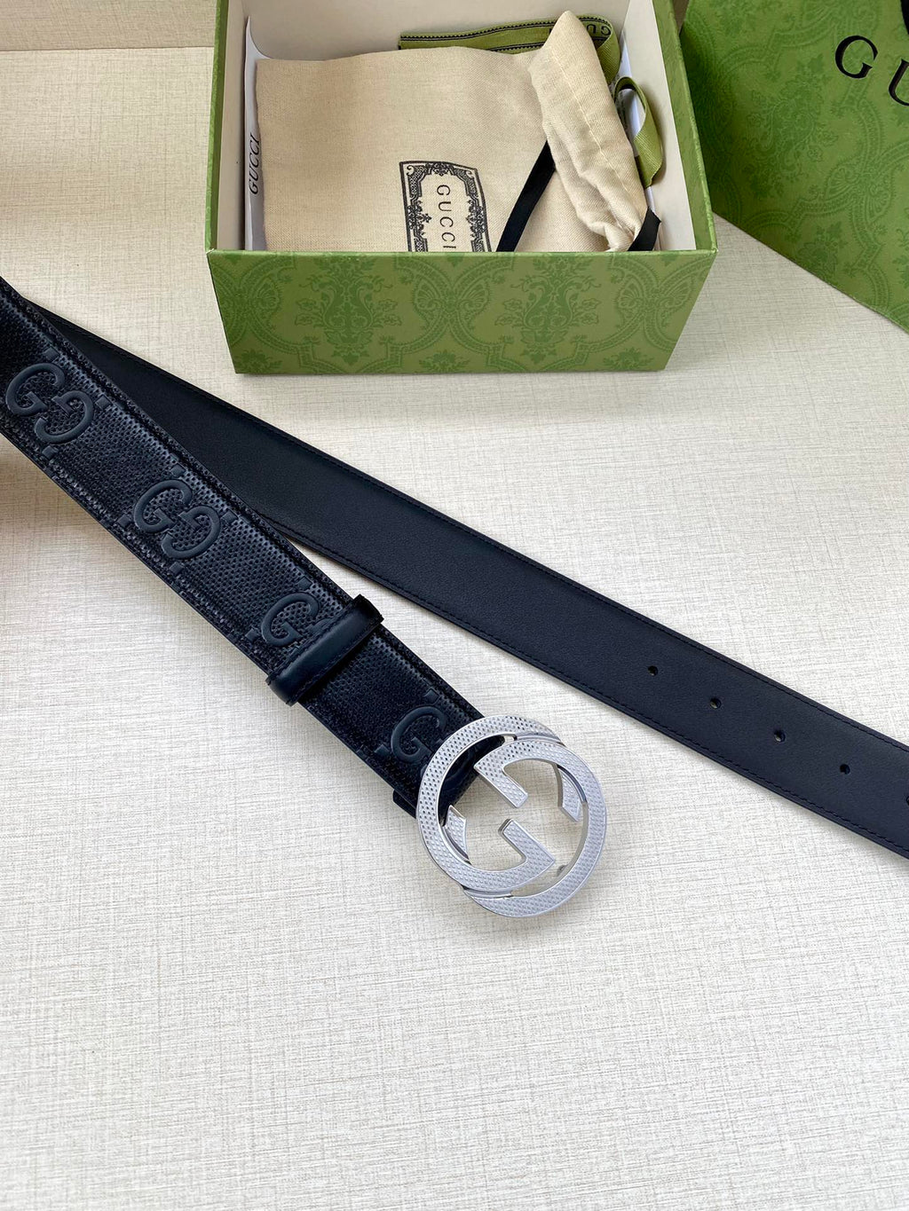 Gucci belt in dark navy with silver interlocking G buckle, belt laid out