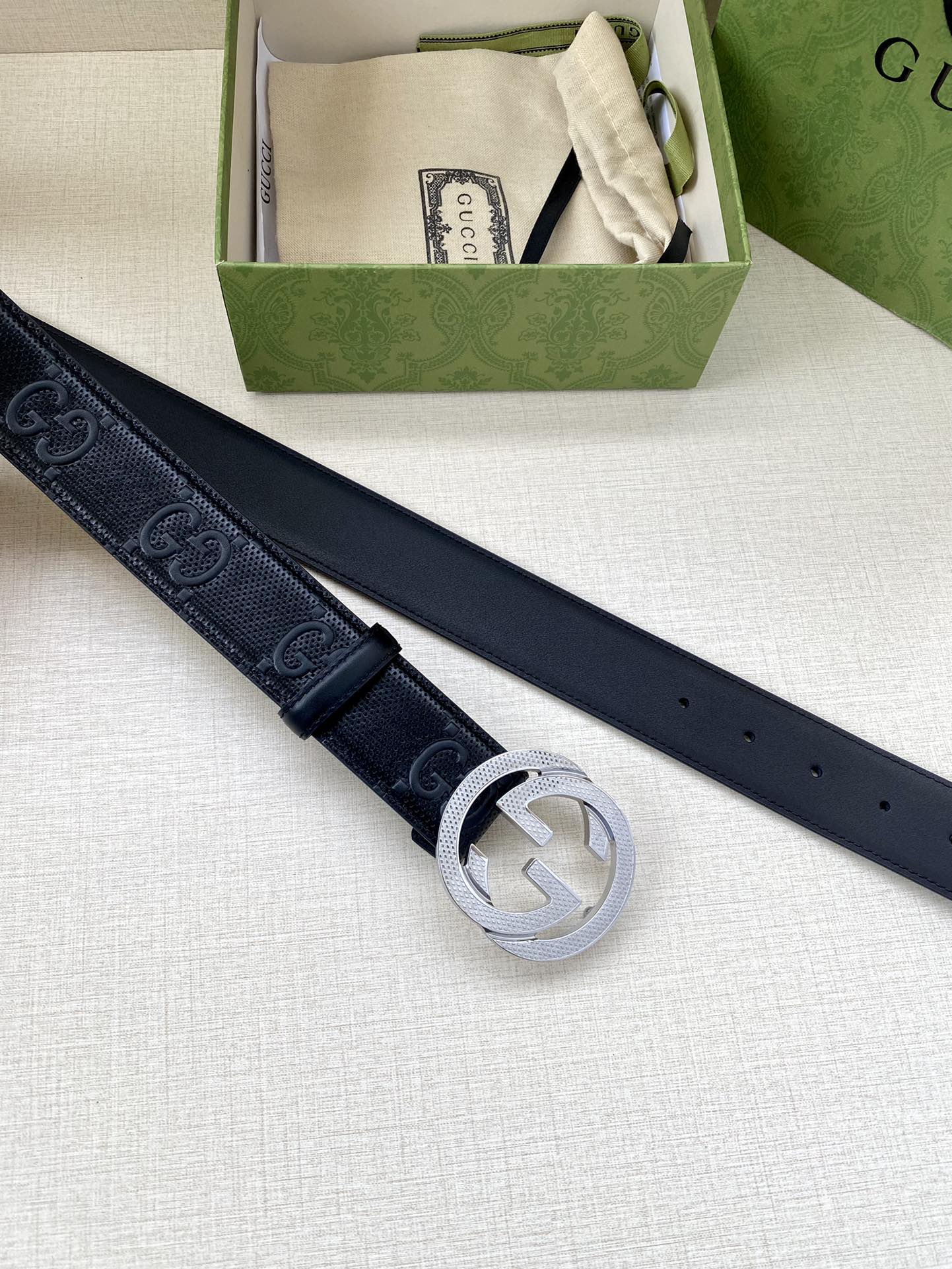 Gucci belt in dark navy with silver interlocking G buckle, belt laid out