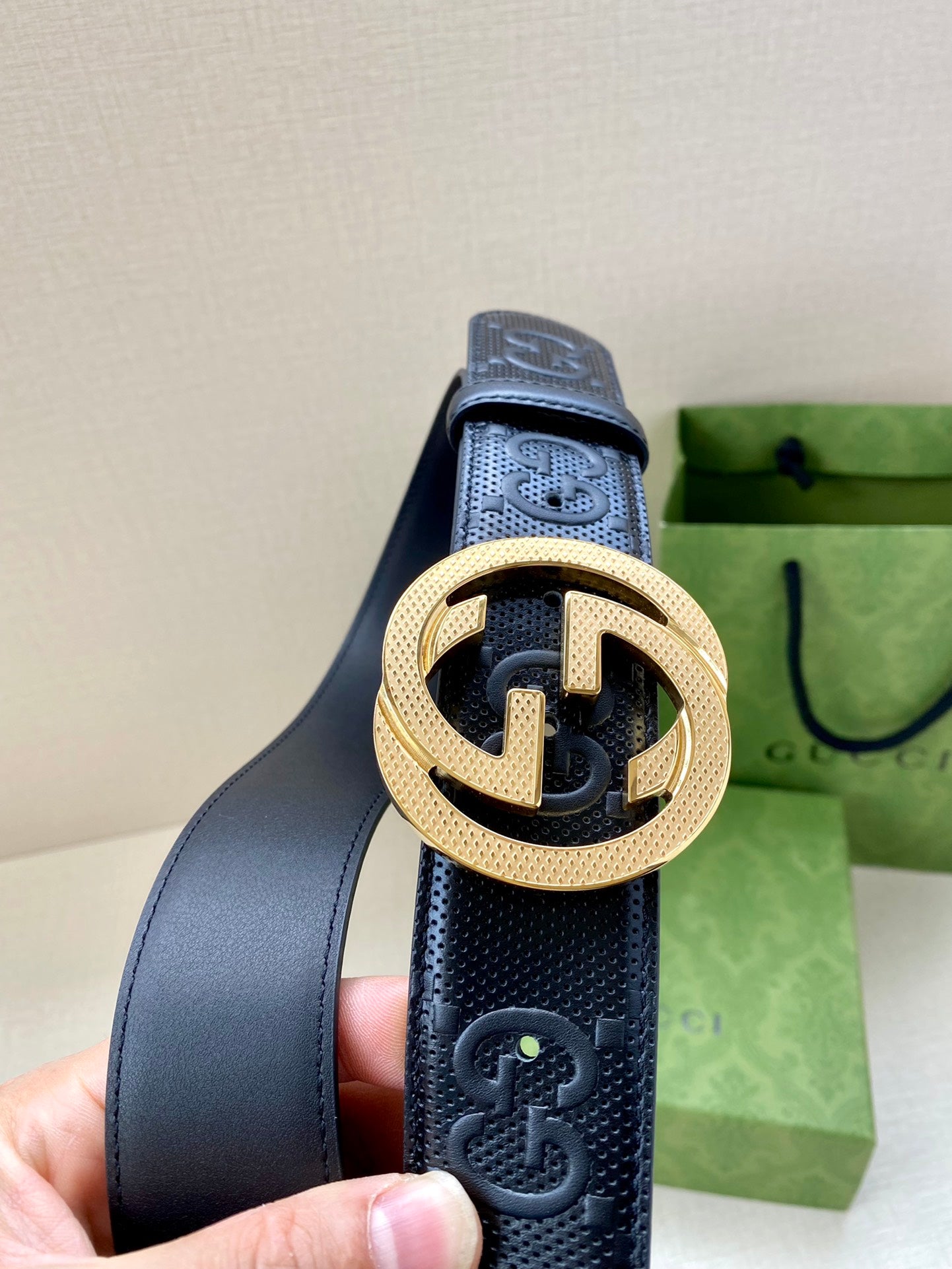 Gucci belt in dark navy with gold interlocking G buckle, close-up on strap