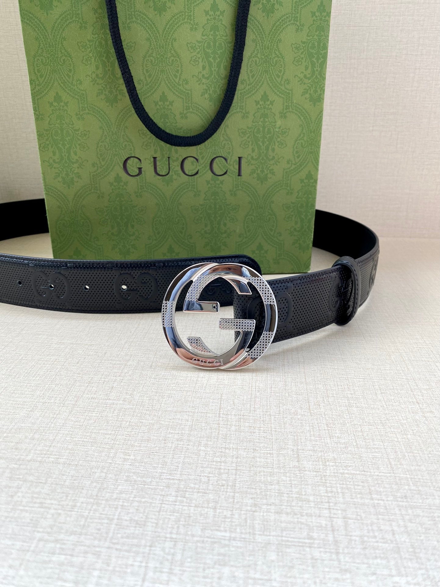 Navy leather belt with embossed logo strap and large silver-toned buckle
