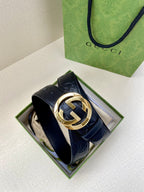 Navy leather Gucci belt with embossed monogram texture and gold-toned interlocking buckle