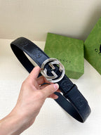 Navy leather Gucci belt with embossed logo pattern and silver-toned buckle