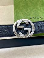 Dark leather belt with perforated logo texture and silver-toned interlocking G buckle
