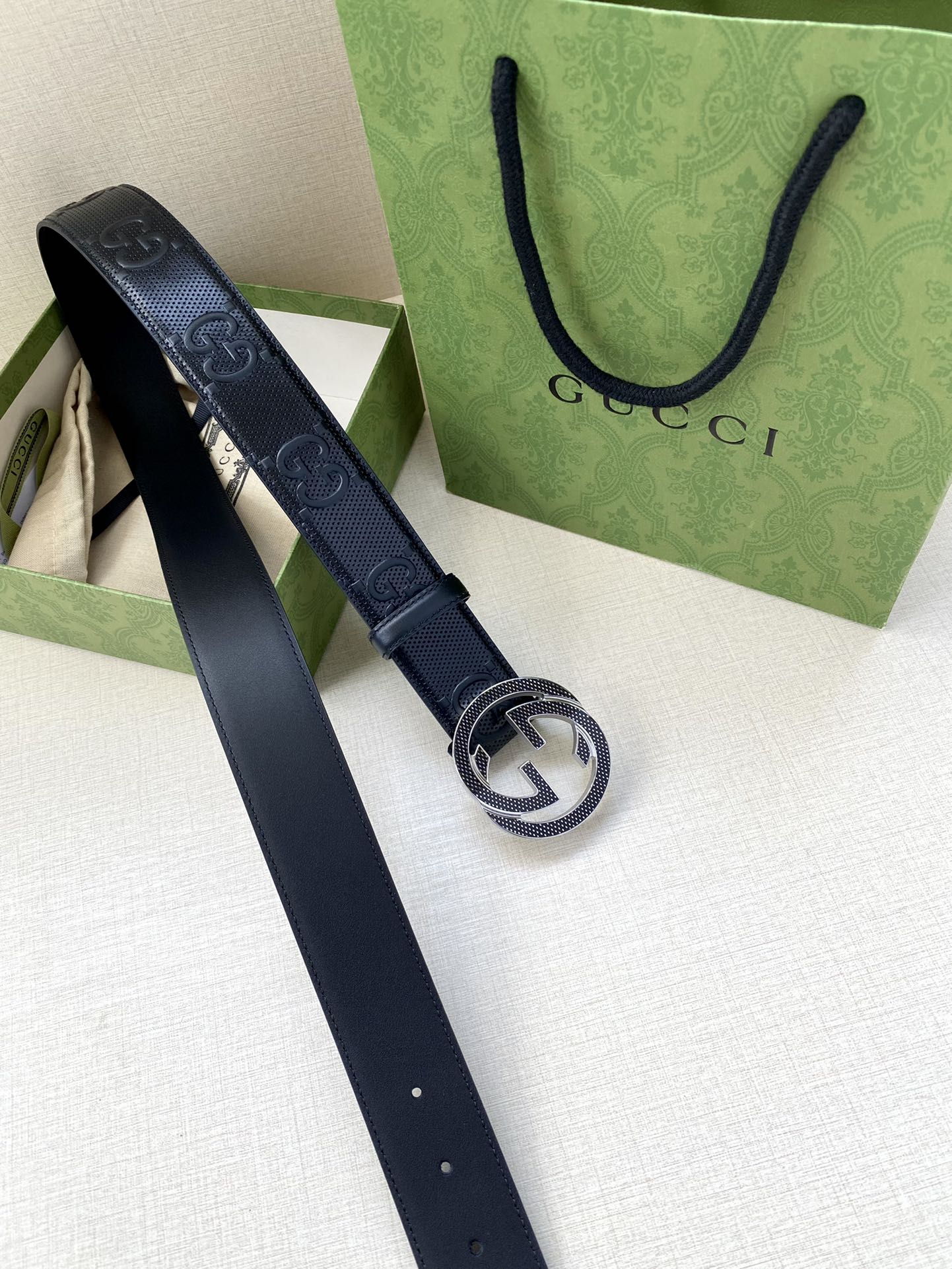 Dark navy belt with Interlocking G buckle and perforated logo embossing