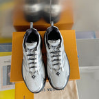 Pair of white Louis Vuitton sneakers with black lining detail and lace-up closure