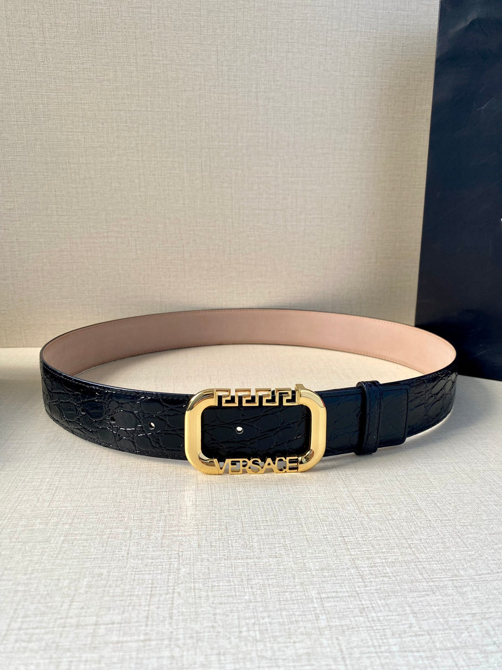 Designer leather belt in dark blue with gold oval buckle and slim strap