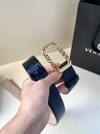 Designer belt with dark blue embossed leather and ornate gold buckle